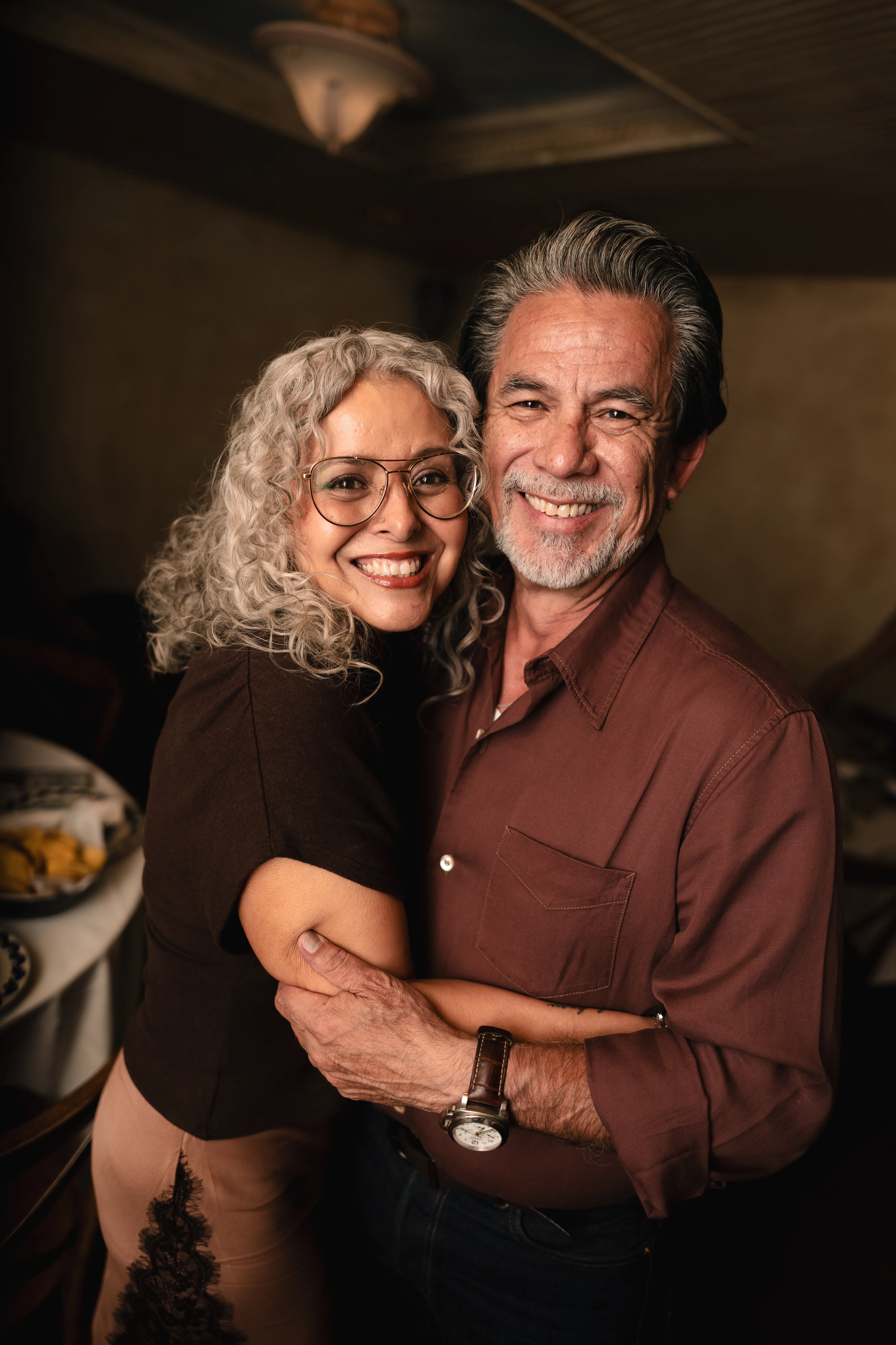 Established couple embracing and smiling, black and white portrait