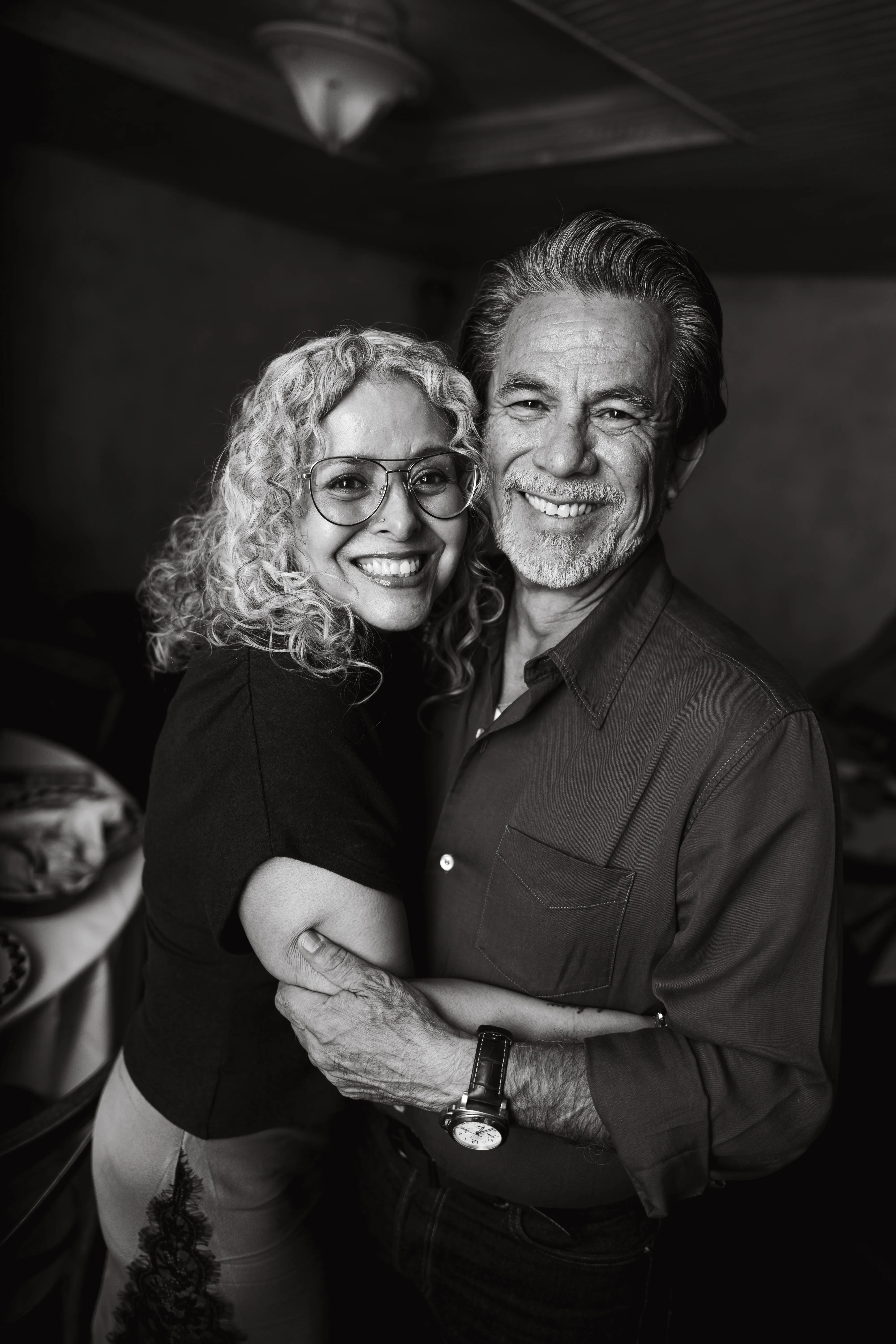 Established couple embracing and smiling, black and white portrait