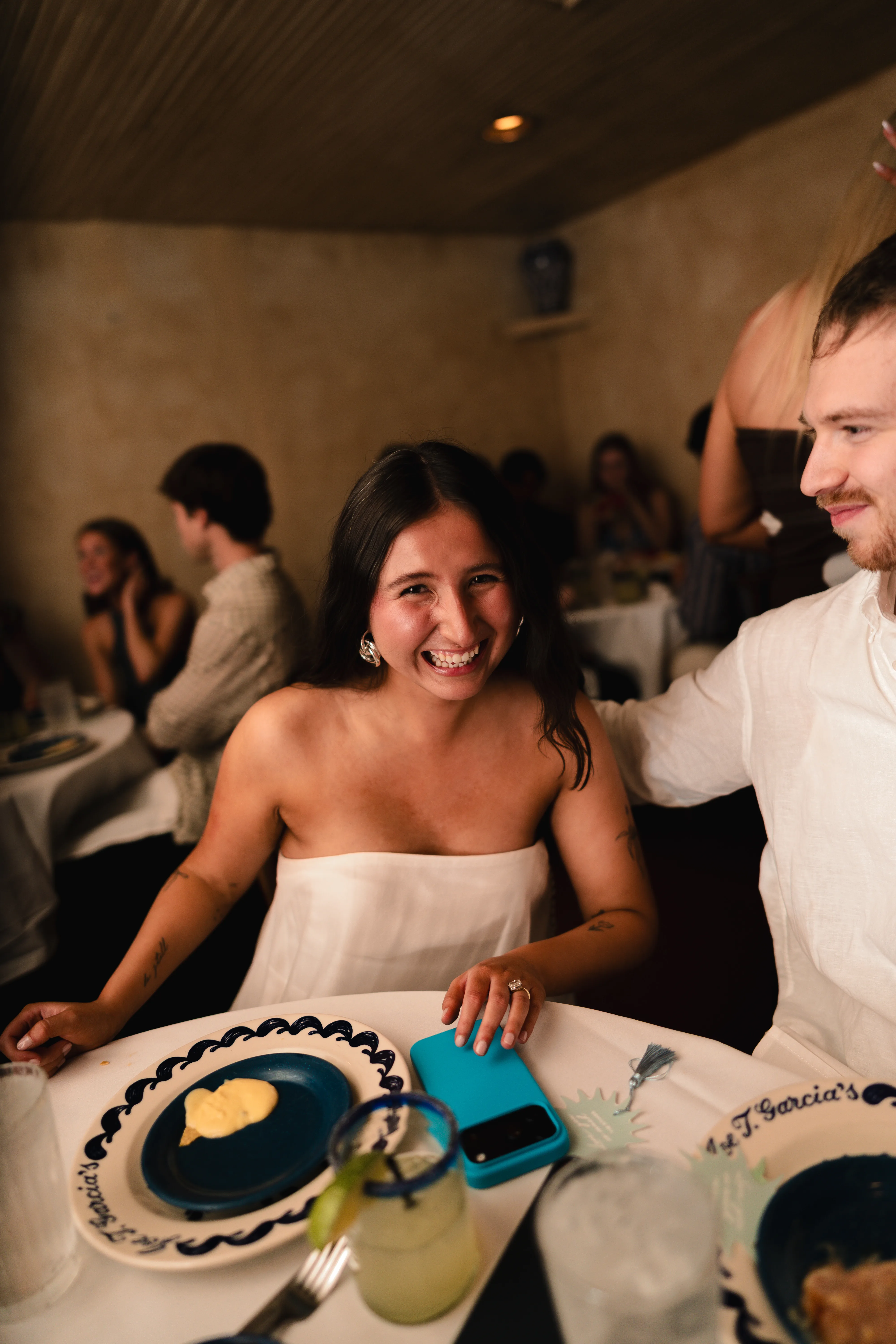 Guest laughing at a candlelit dinner table during a celebration