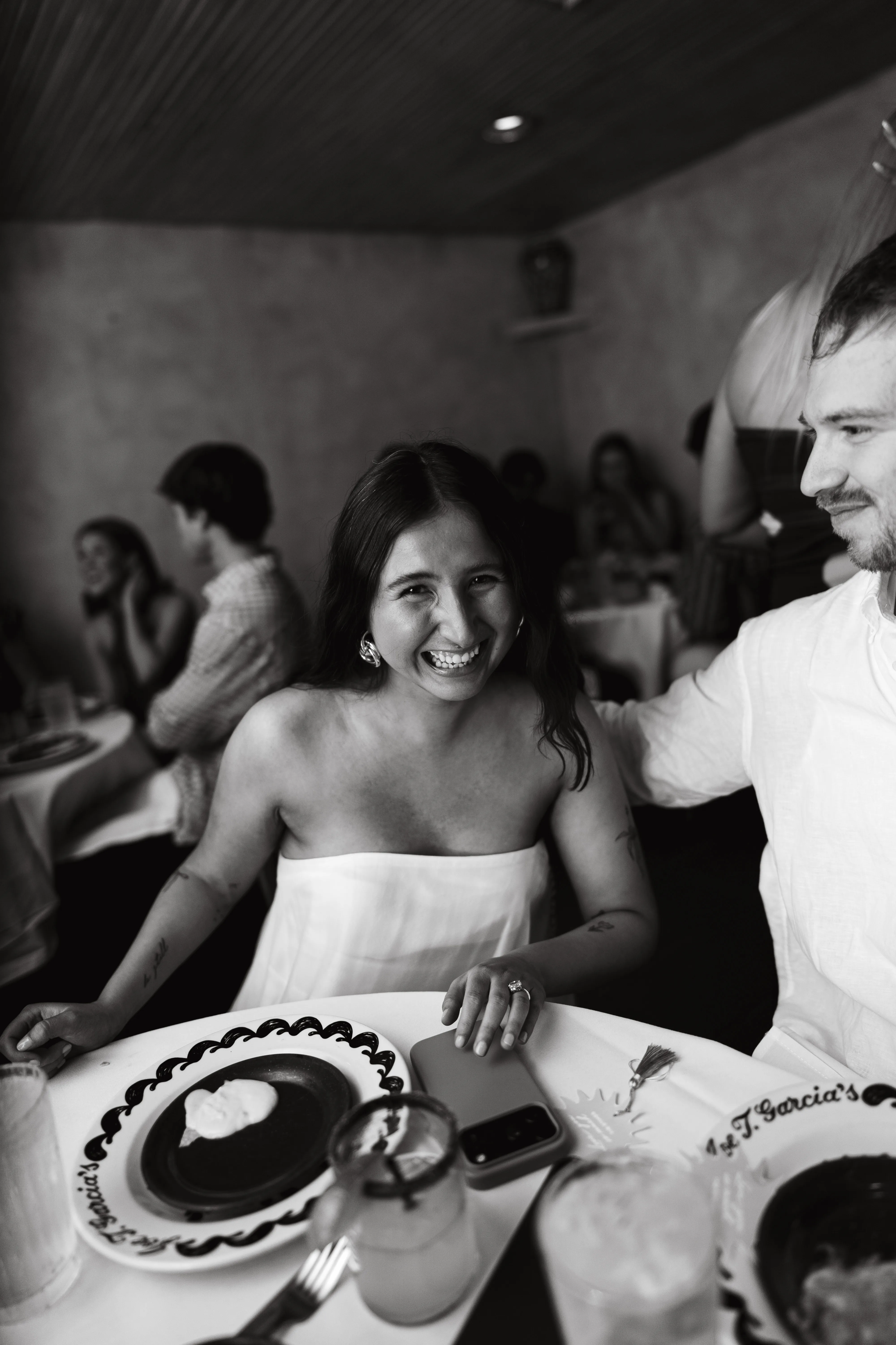 Guest laughing at a candlelit dinner table during a celebration