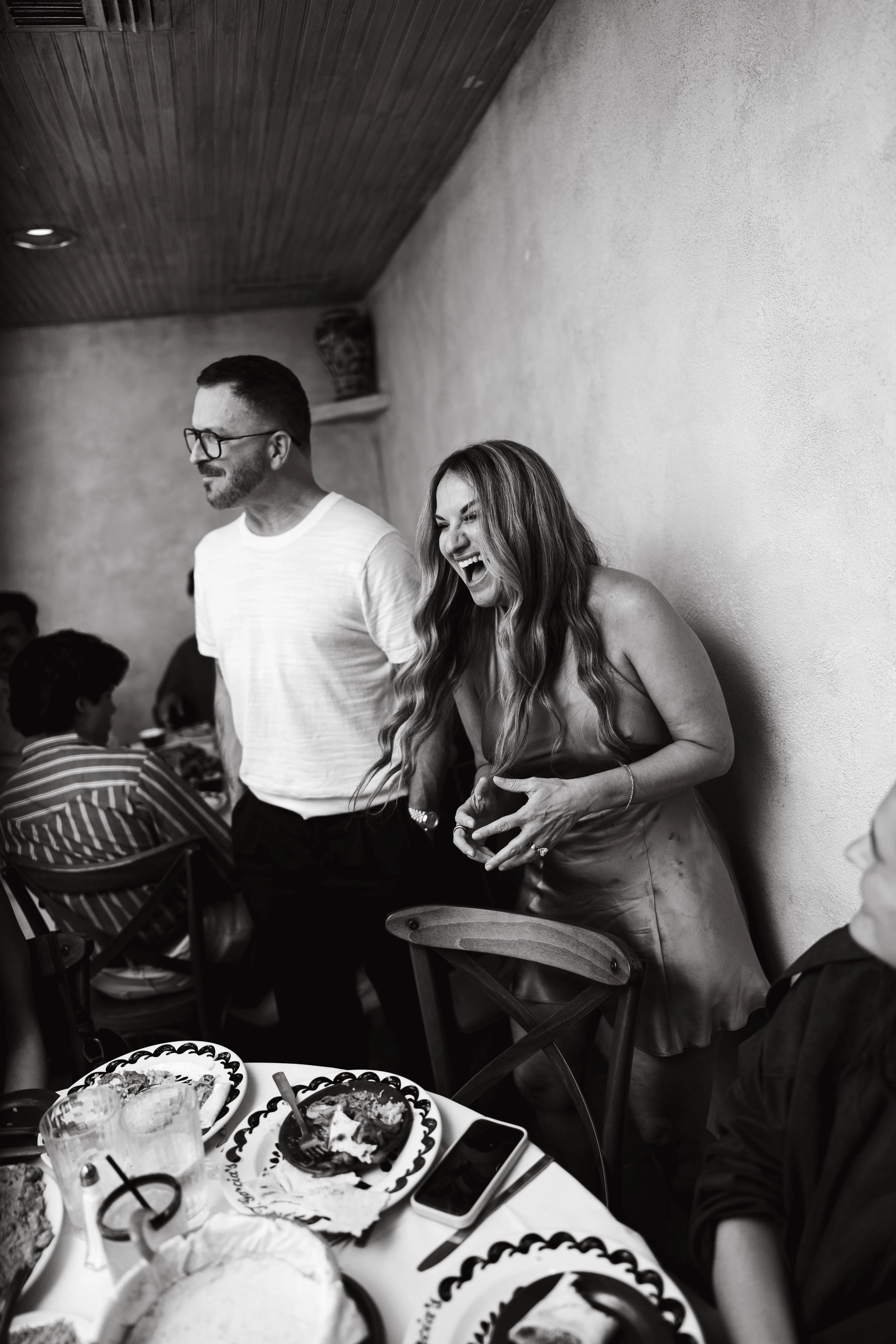 Guests laughing together at a restaurant during an event