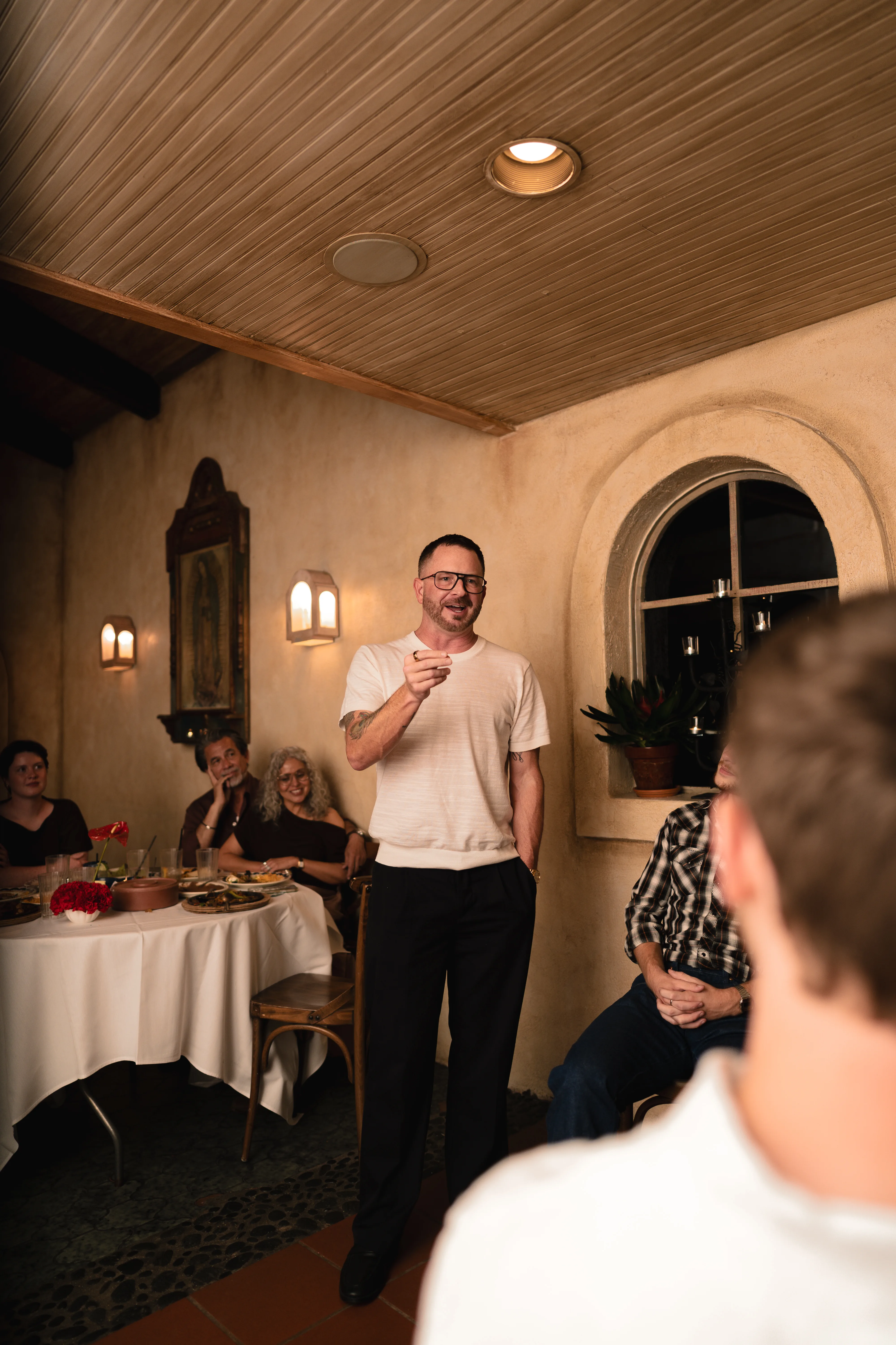 Man giving a toast to guests at a celebration dinner