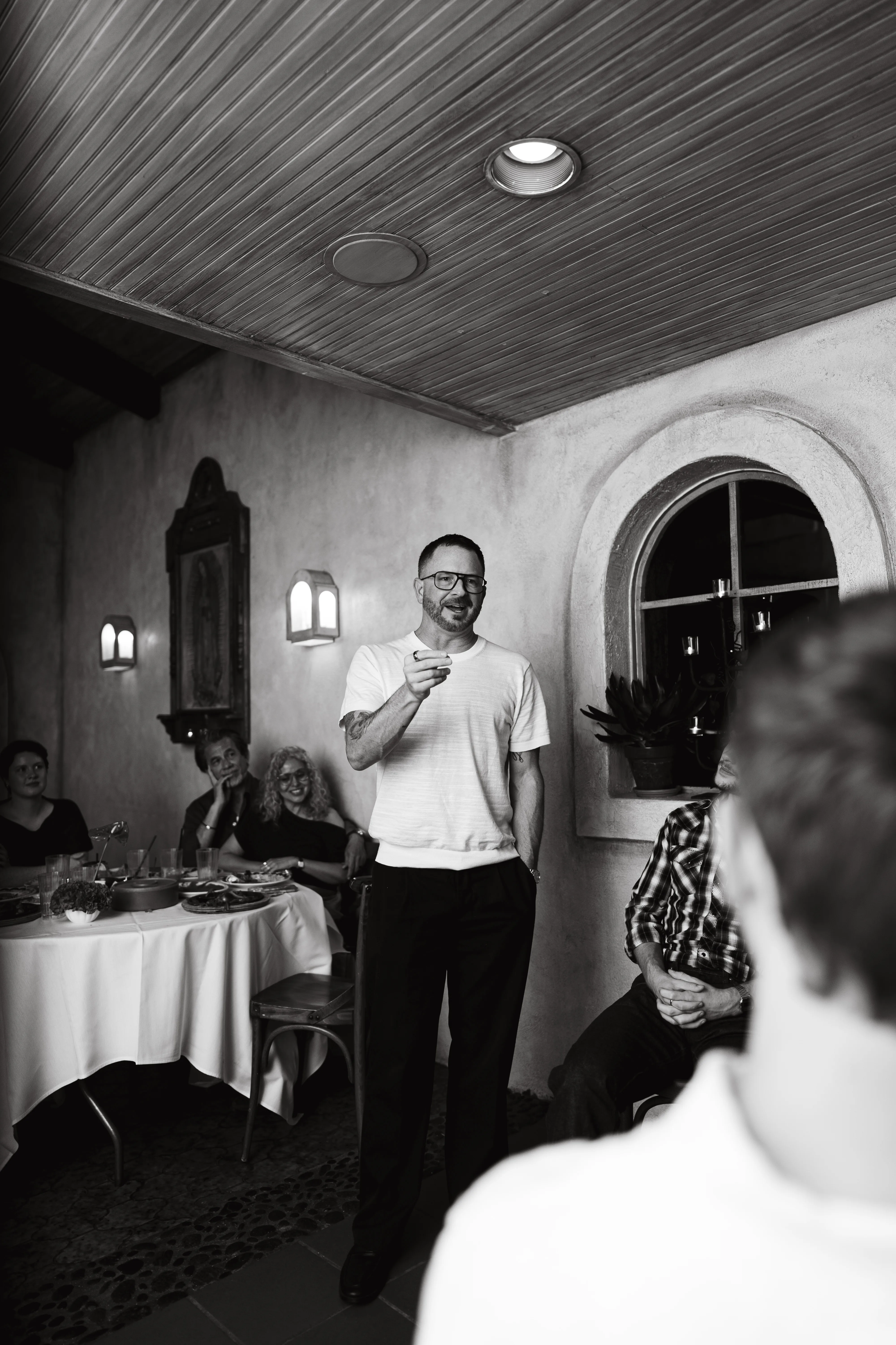 Man giving a toast to guests at a celebration dinner