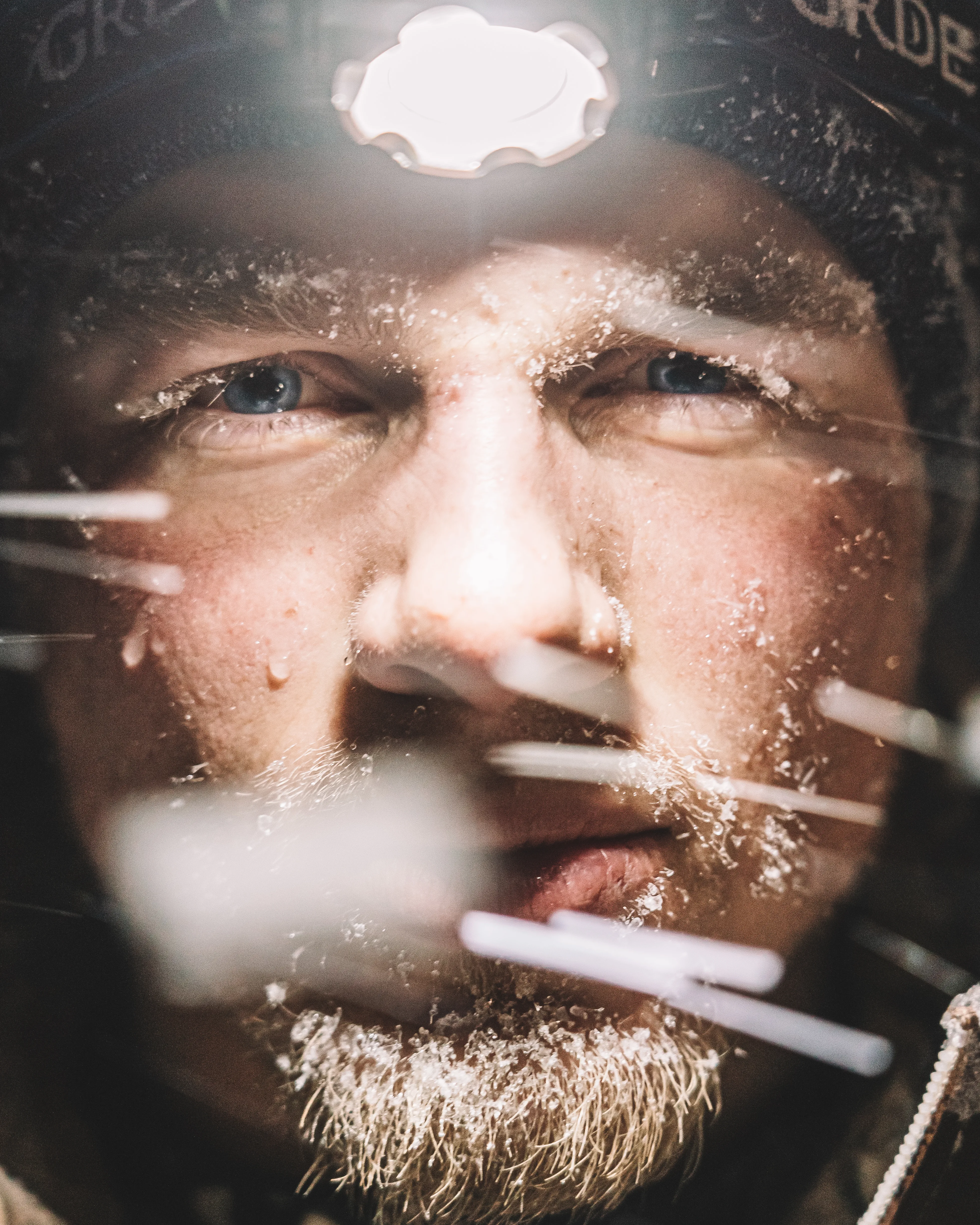 Close-up portrait lit by a headlamp, outdoors at night