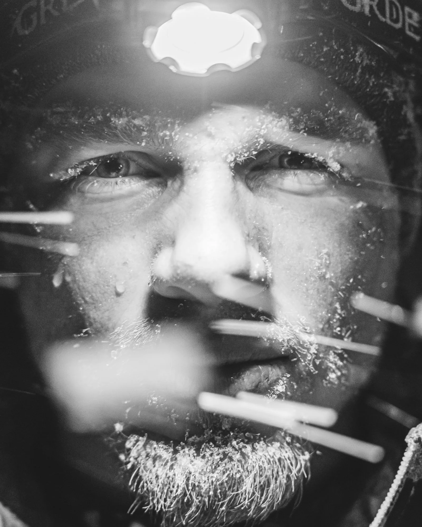 Close-up portrait lit by a headlamp, outdoors at night